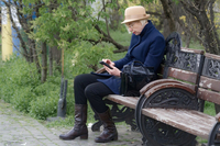 Frau auf Bank mit Smartphone klein